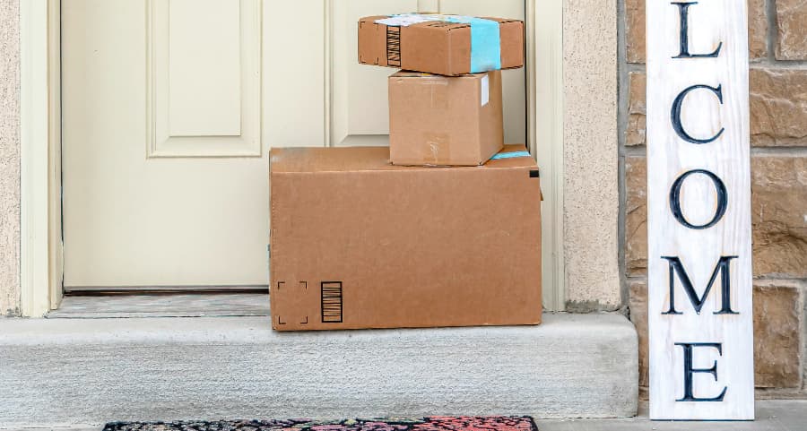 Boxes by the door of a residence with a welcome sign in Chandler